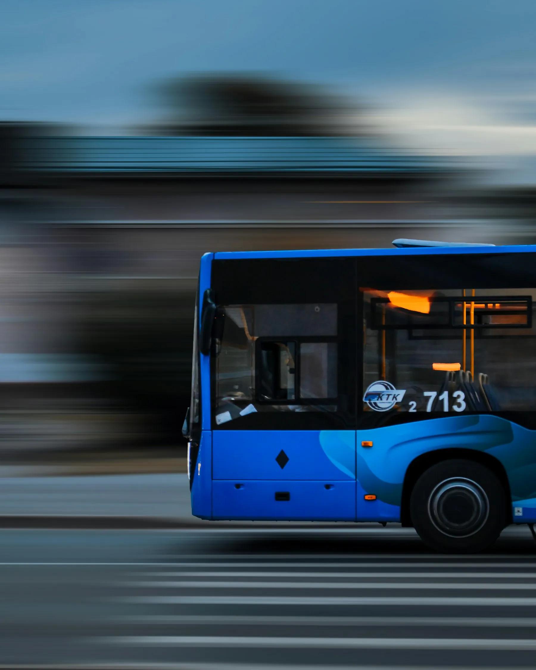 A blue bus traveling through a city street
