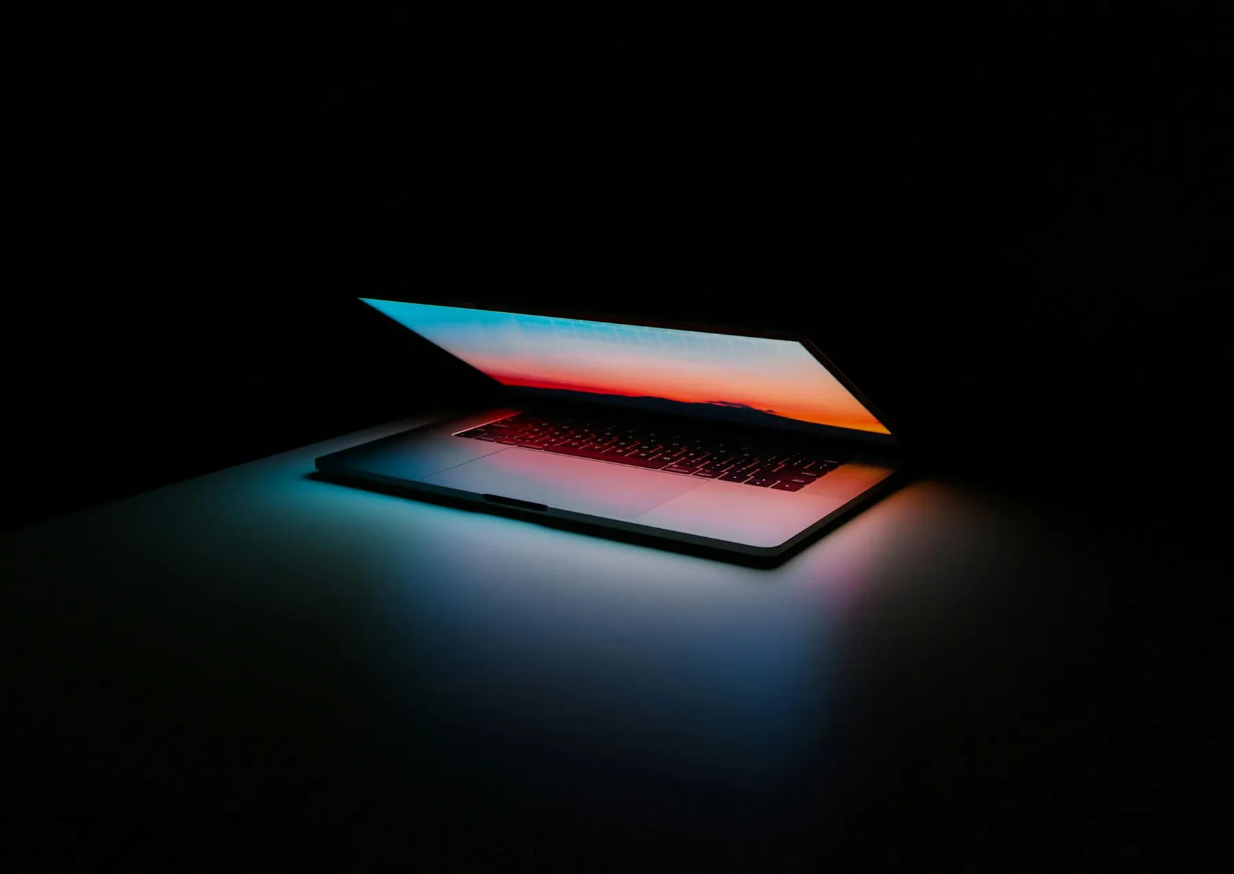 A laptop open on a dark desk