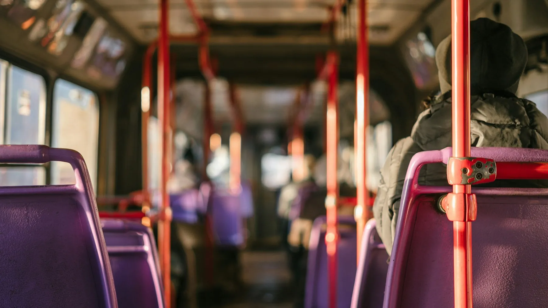 A person standing inside a public transit vehicle