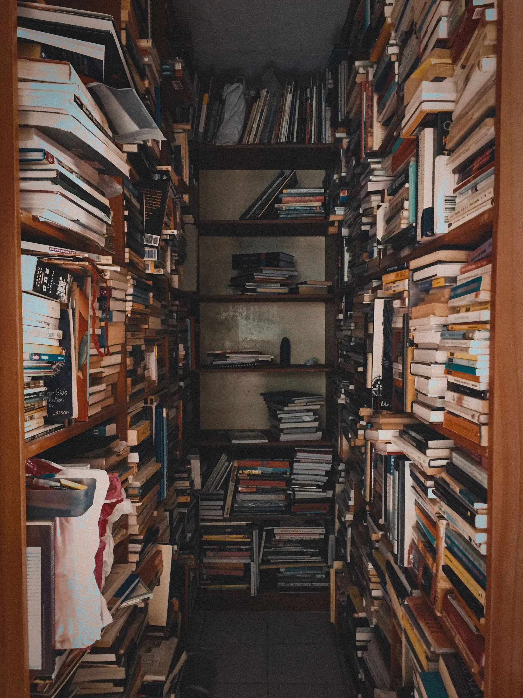 A narrow archive aisle crowded with books