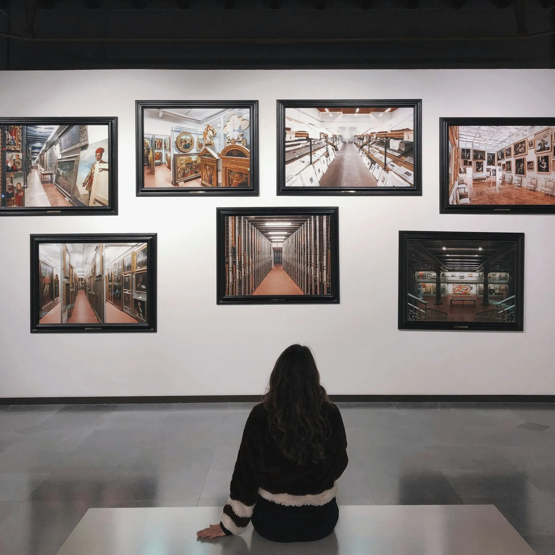 A visitor seated on the floor of a contemporary gallery