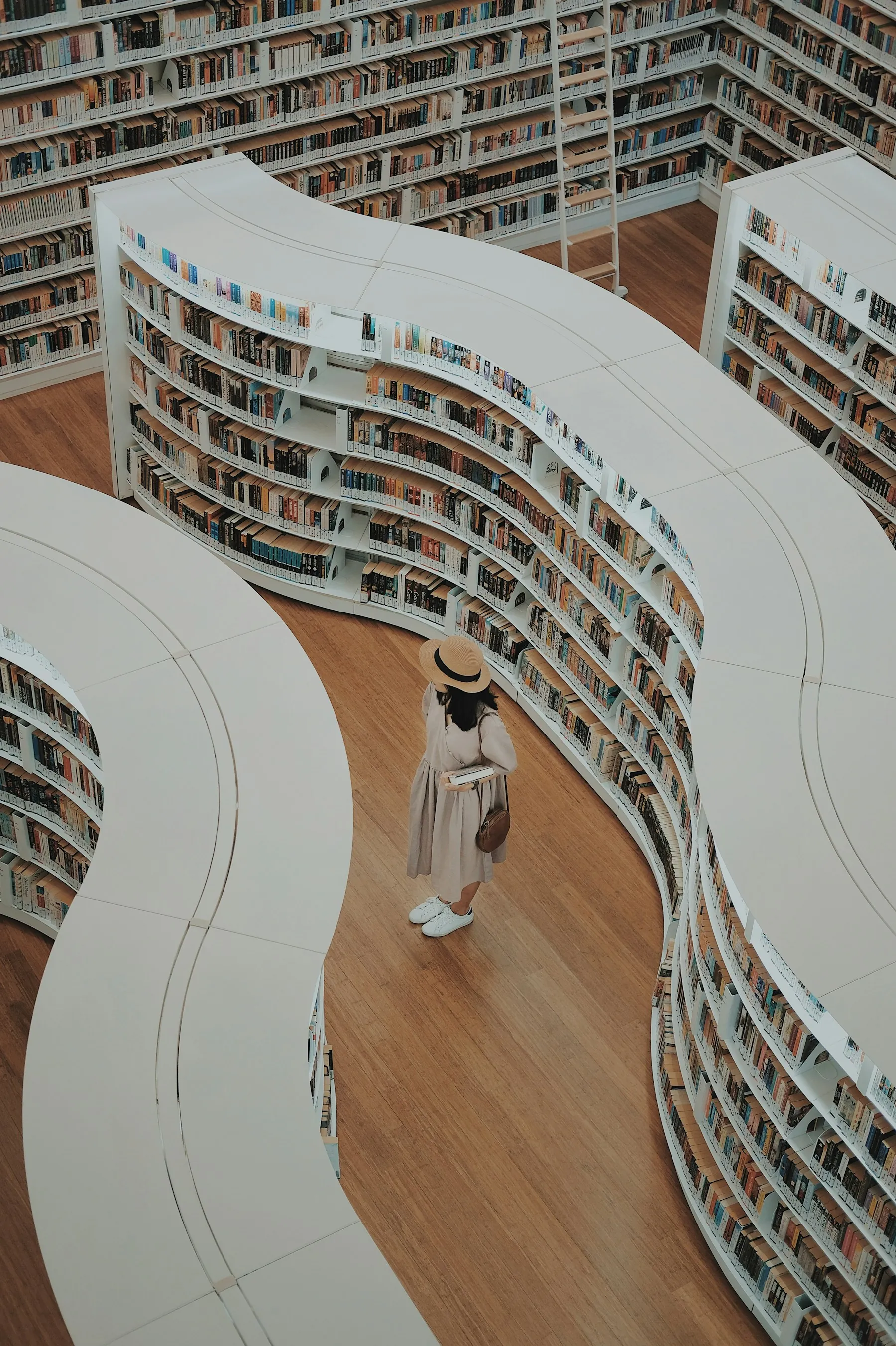 A person browsing books in a tall library